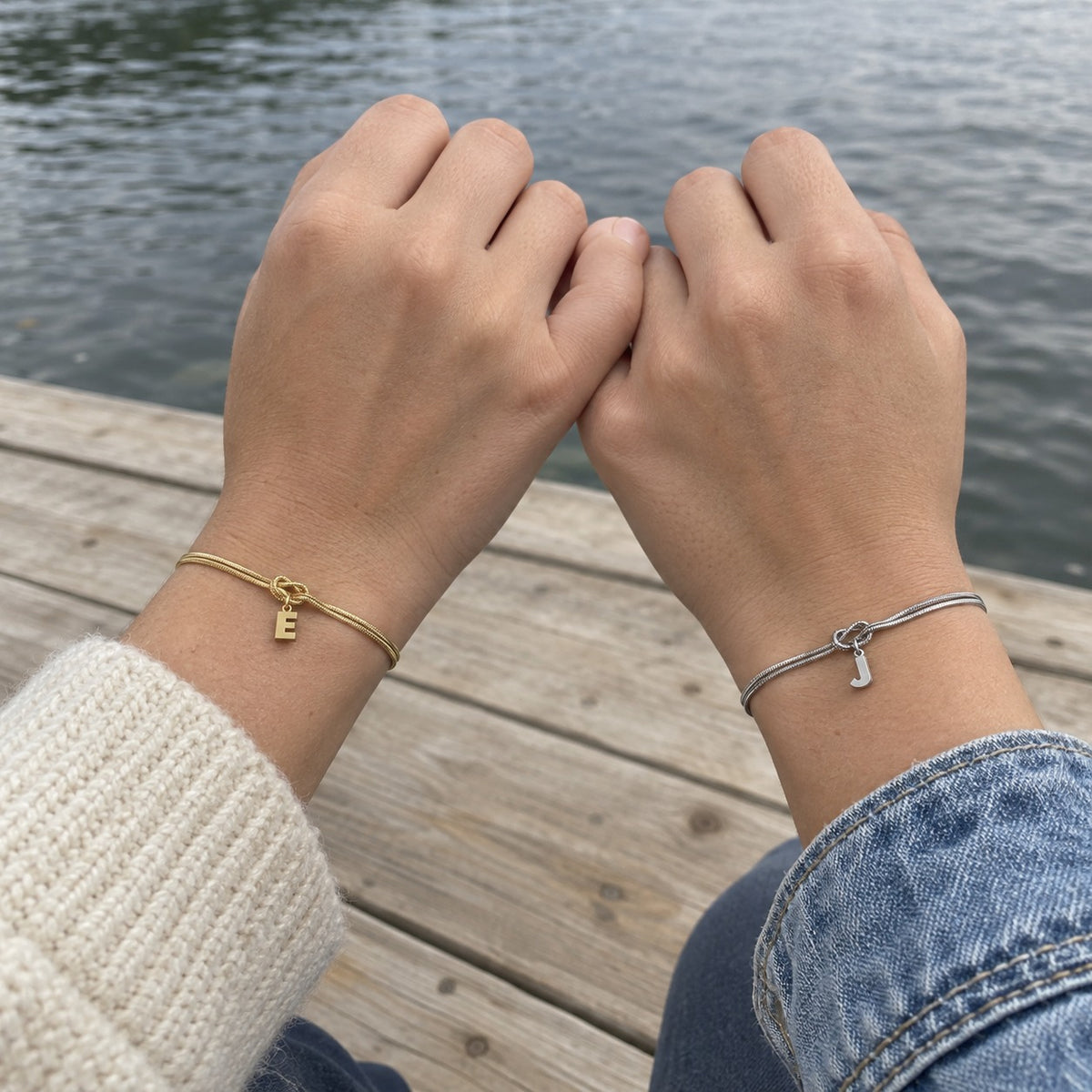 Deux amies, un bracelet or E et un bracelet argent J