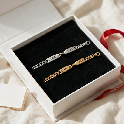 Coffret Liora ouvert sur un drap : bracelet argent et bracelet or gravés CLARA · JULES